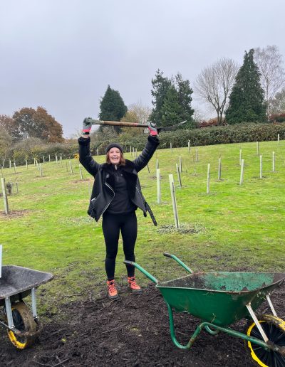 Tilly Gilmour holding a spade over her head in a victory pose